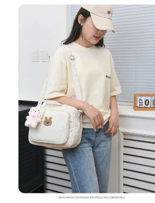 sac à langer blanc avec pendentif ourson porter sur épaule